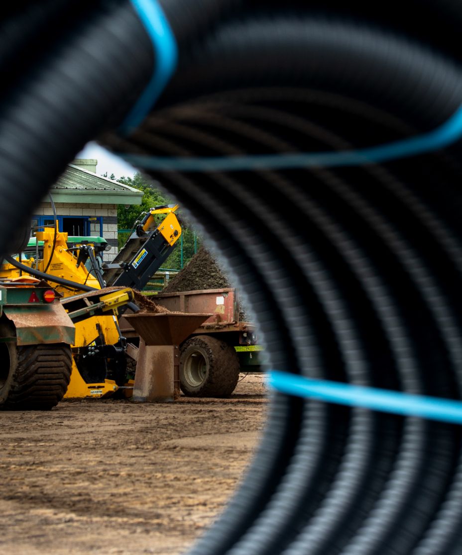 sports pitch drainage pipes next to excavator