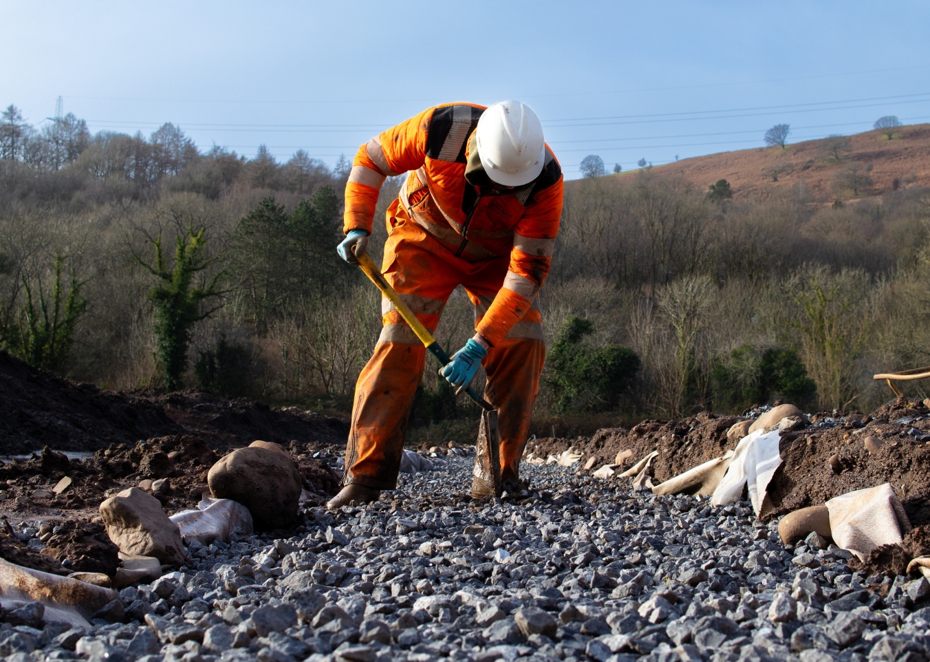 man moving stones with shovel
