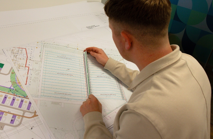 person drawing up plans of a sports pitch design