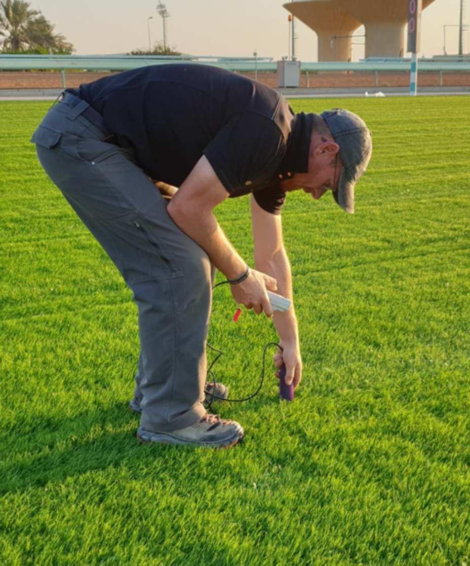man testing area for horse riding arena construction