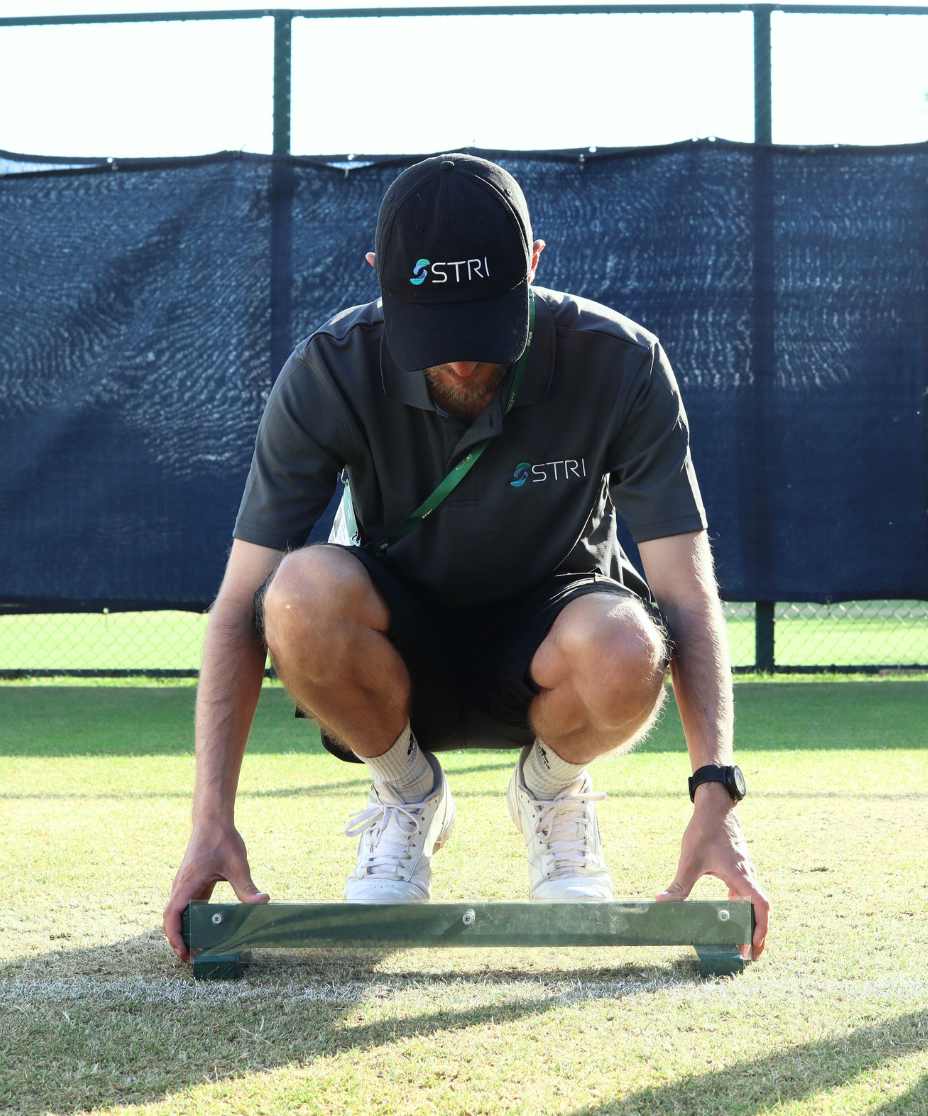 person taking measurements on a tennis court