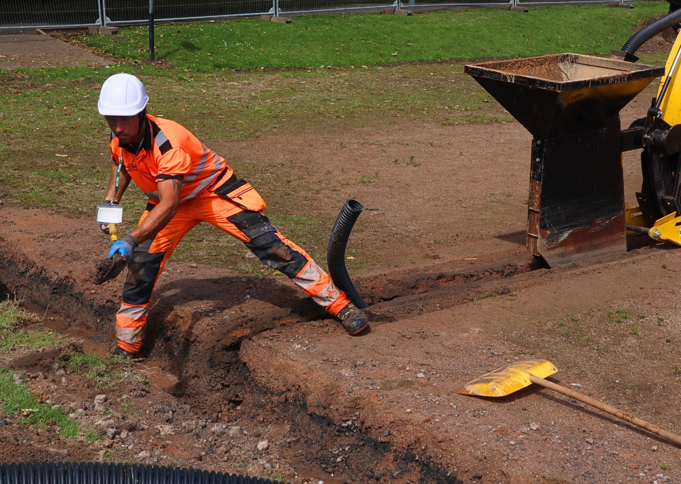 person moving rubble from a drainage channel