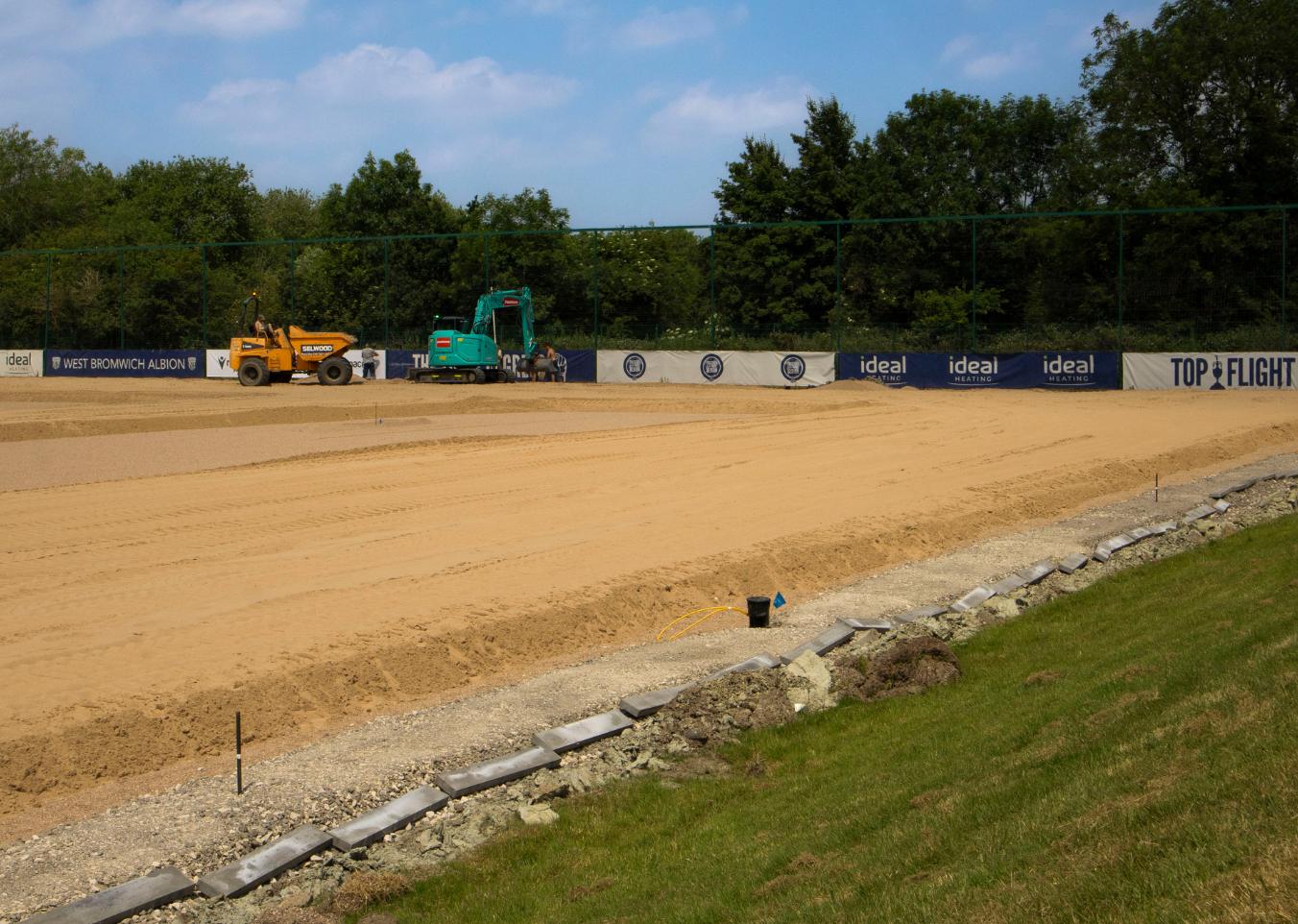 sand being spread and levelled on pitch
